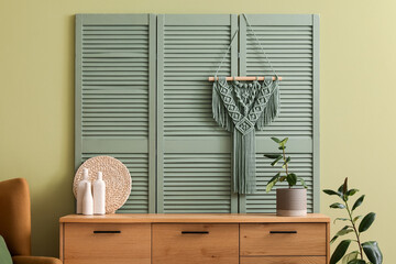 Decor bottles and plant on chest of drawers in living room