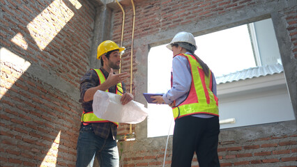 Architects and engineers work together to assess the residential home construction site's progress