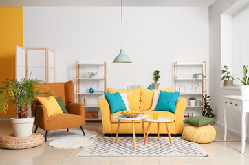 Interior of beautiful living room with yellow sofa, coffee table, armchair and shelving unit
