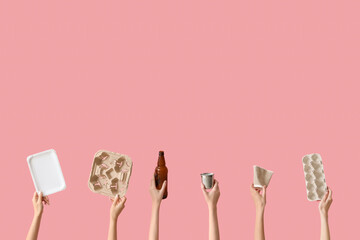 Female hands holding different garbage on pink background. Recycling concept