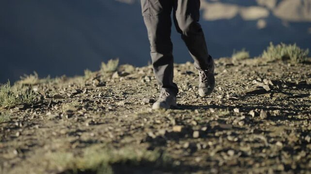 4K footage of Indian man walking peacefully on a mountain ridge in Ladakh, Lamayuru moonland of India, admiring the view.
