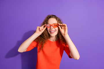 Young Woman Wearing Stylish Red Shirt and Glasses Against Purple Background