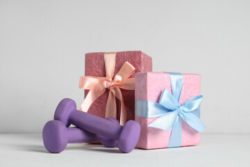 Purple dumbbells and gift boxes on white background