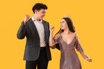 Pretty prom couple dancing on yellow background