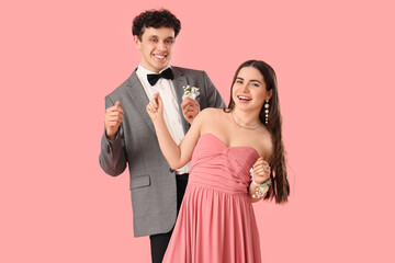 Happy prom couple dancing on pink background
