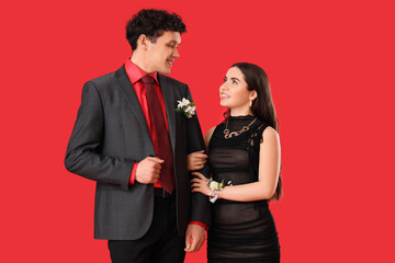 Pretty prom couple on red background