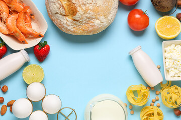 Frame made of different products on blue background. Food Allergy Awareness Month
