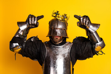 Armored Knight Wearing a Crown on Vibrant Yellow Background Displaying Confidence and Regal Charm