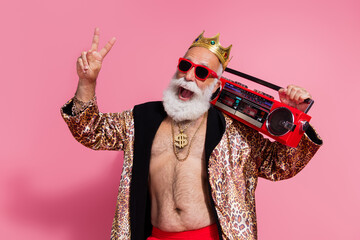 Photo of crazy funny aged man show v-sign dance listen music boombox wear glamour leopard print clothes isolated on pink color background