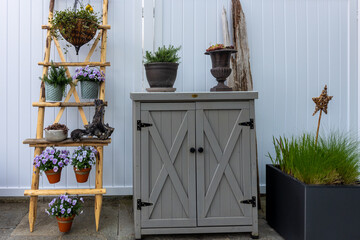 Garden cabinet with a variety of plants like pansy and rosemary and decorations enhancing outdoor...