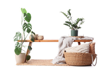 Wooden bench with baskets and plants on white background