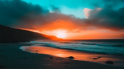 Obraz premium Ocean waves meet sandy beach at sunset with colorful sky and silhouette mountain.