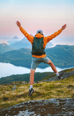 Man traveler happy jumping in mountains travel summer active vacations outdoor, tourist hiking healthy lifestyle freedom success concept mental health wellness eco tourism backpacking in Norway
