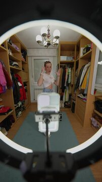 Young influencer creating engaging content for social media in walk in closet