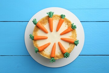 Delicious homemade carrot cake on light blue wooden table, top view
