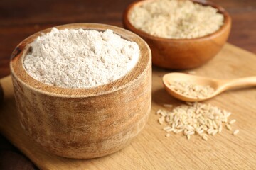 Brown rice and flour on wooden table, closeup