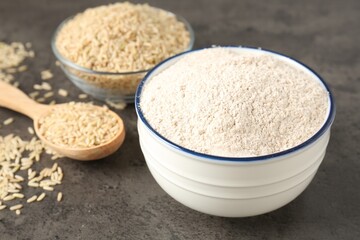 Brown rice and flour on grey table, closeup
