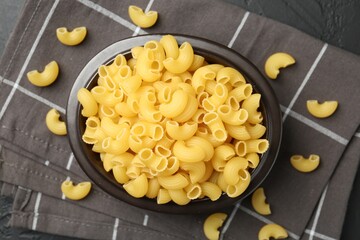 Raw horns pasta in bowl on table, top view
