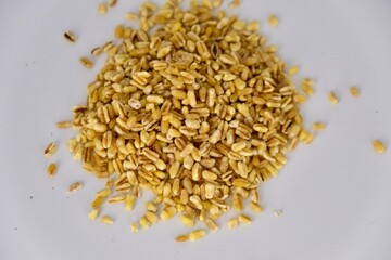 close up image of a small heap of spelt cereal over a white background