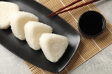 Tasty onigiri (Japanese rice balls) served on grey table, flat lay