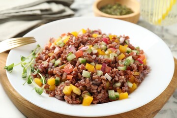 Tasty salad with brown rice on white table, closeup