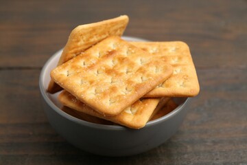 Tasty salty crackers on wooden table, closeup