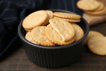 Tasty salty crackers on wooden table, closeup