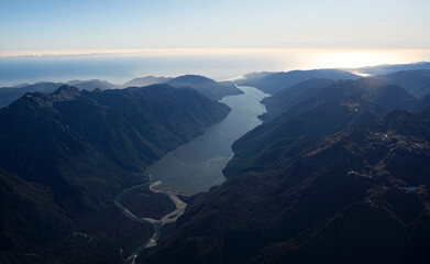 Lake McKerrow Whakatipu Waitai between Southern Alps foothill mountain valley with Southland coastline in background, untouched New Zealand landscape