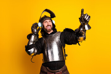 A knight clad in armor enjoying music through headphones against a yellow background