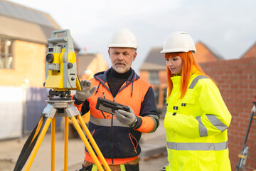 Construction surveyors professionals collaborating on site survey using equipment and technology...