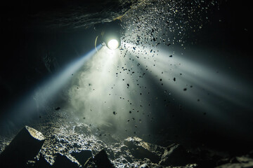 room simulating deep cave dive, light from helmet piercing darkness, echo depth