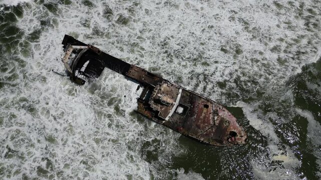 Aerial drone view of Zeila Shipwreck Namibia surrounded by foamy waves on the South Atlantic Ocean