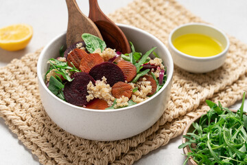 Quinoa salad with arugula, beetroot and carrot. Detox, diet, healthy salad in white bowl on light background