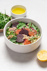 Quinoa salad with arugula, beetroot and carrot. Detox, diet, healthy salad in white bowl on light background