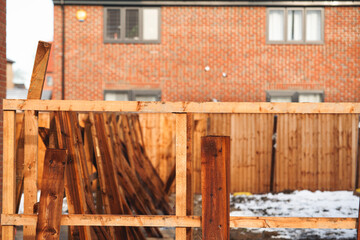 Construction of wooden fence in neighborhood under clear sky during winter