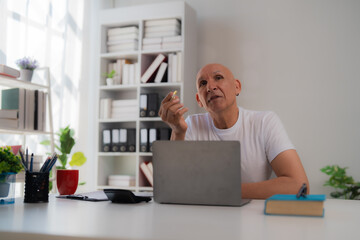 Focused business professional stands by a window, using a tablet. The city lights create a modern,...