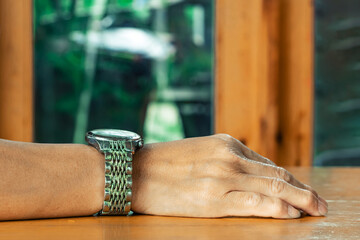 Dirt and sweat stains corrode old steel or metal wrist watch strap that have not been cleaned for long time on hand of woman. Dirty old wrist watch steel strap.Old shabby watch with dirty metal strap