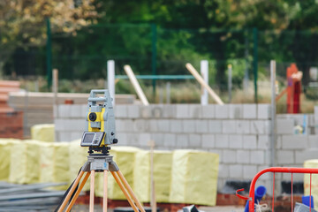 Measuring equipment positioned at construction site near building materials and walls