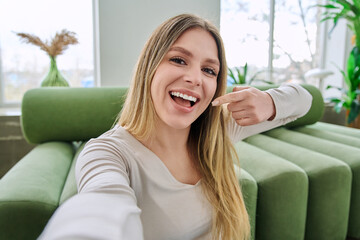 Beautiful happy smiling young woman healthy natural teeth on camera, selfie view