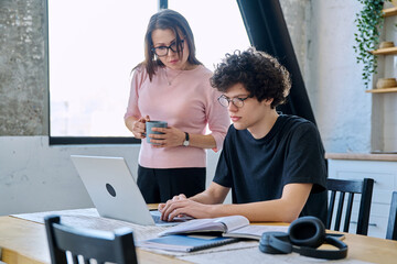 Middle aged mother and son university student, together at home