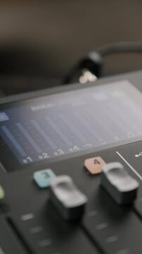 Hand adjusting fader on sound mixing console
