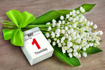 Calendar May 1  Thursday 2025 and flowers on wooden backround  Labour Day