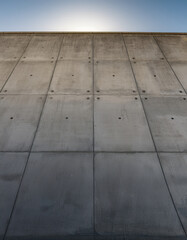 A smooth, minimalist concrete wall provides a clean and modern backdrop, suggesting simplicity and industrial design with its stark texture and neutral tone.