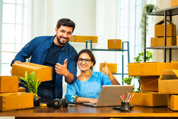 Small Indian business partners handling garment packaging and laptop inventory entry