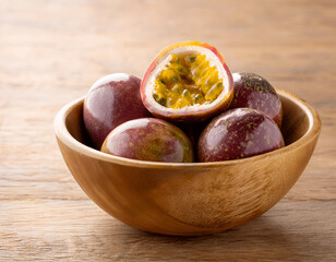 Obraz premium Passion fruit in an empty plate on a wooden table, top view. Tropical fruit still life