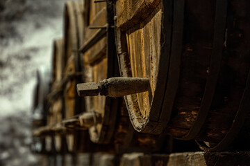 Close-up of old wooden barrels in a rustic winery for aging wines and spirits.