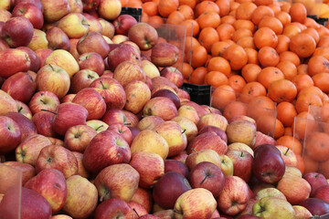 Close-up of red apples overflowing in plastic crates at a rustic market. Perfect for agricultural blogs, grocery chain promotions, or farm-to-table content bounty and food distribution systems