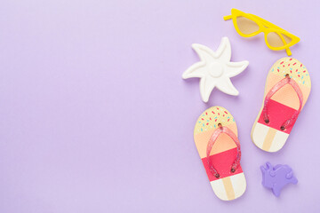 Children's flip flops and beach toys on color background,,top view