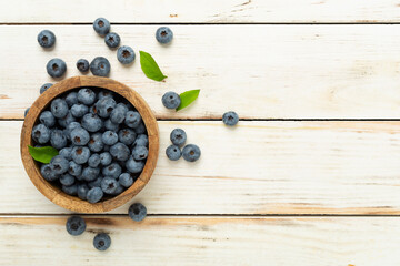 Bowl with fresh bright blueberries on wooden background,top view