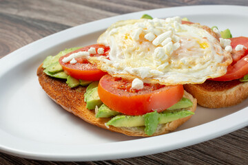 A view of avocado toast, topped with a fried egg.